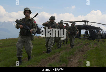 A team of Turkish soldiers, serving as a reactionary force for the Multinational Battle Group-East, transfer from a UH-60 Black Hawk to a Swiss AS-332 Super Puma in response to a downed air craft scenario during Operation Icarus in Kosovo, June 8, 2016. (U.S. Army photo by: Staff Sgt. Thomas Duval, Multinational Battle Group-East Public Affairs) 2645205 Turkish soldiers, serving as a reactionary force for the KFOR Multinational Battle Group-East in Kosovo Stock Photo