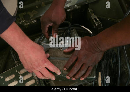 Multiple Integrated Laser Engagement Systems (MILES) specialists install a sync cord for MILES onto a Slovenian M-84 main battle tank of 45th Center for Tracked Combat Vehicles (CGBV) during Swift Response 16 training exercise at the Hohenfels Training Area, a part of the Joint Multinational Readiness Center, in Hohenfels, Germany, Jun. 8, 2015. Exercise Swift Response is one of the premier military crisis response training events for multi-national airborne forces in the world. The exercise is designed to enhance the readiness of the combat core of the U.S. Global Response Force – currently t Stock Photo