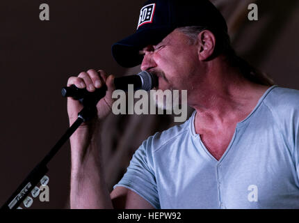 Country music star Trace Adkins sings into the microphone during a concert to show his support for the United States military at Camp Arifjan, Kuwait as part of the USO’s 75th Anniversary Concert Series, June 8. Adkins also spent time with the troops answering questions, signing autographs and posing for photos. (Photo by Spc. Angela Lorden/Released) Trace Adkins Performs for Servicemembers in Kuwait (Image 1 of 4) 160608-A-GP059-001 Stock Photo