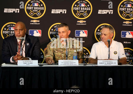 Lt. Gen. Stephen Townsend, Commanding General, XVIII Airborne Corps, answers a question from the press alongside Major League Baseball Player Association Executive Director Tony Clark, and Robert D. Manfred Jr., Commissioner for Major League Baseball, during a press conference prior to the start of the Atlanta Braves and Miami Marlins regular season game played at Fort Bragg Field on Sunday, July 3, 2016 at Fort Bragg, N.C. Fort Bragg, MLB and the MLBPA teamed up to put on the historic regular season game between the Braves and Marlins at Fort Bragg. (US Army photo by Staff Sgt. Jason Duhr) 20 Stock Photo