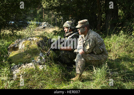 U.S. Army Cpt. Cristian Radulescu, right, of the Joint Multinational Readiness Center (JMRC) Warhog Observer Coacher Trainer Team and a Romanian soldier of the 33rd Mountain Battalion Posada observes the soldiers sector of fire prior to conducting a planning rehearsal during exercise Combined Resolve VII at the U.S. Army’s JMRC in Hohenfels Germany, Sept. 8, 2016. Combined Resolve VII is a 7th Army Training Command, U.S. Army Europe-directed exercise, taking place at the Grafenwoehr and Hohenfels Training Areas, Aug. 8 to Sept. 15, 2016. The exercise is designed to train the Army’s regionally  Stock Photo