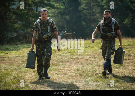 Romanian soldiers of the 33rd Mountain Battalion Posada carry water containers while conducting a resupply operation during exercise Combined Resolve VII at the U.S. Army’s Joint Multinational Readiness Center in Hohenfels Germany, Sept. 11, 2016. Combined Resolve VII is a 7th Army Training Command, U.S. Army Europe-directed exercise, taking place at the Grafenwoehr and Hohenfels Training Areas, Aug. 8 to Sept. 15, 2016. The exercise is designed to train the Army’s regionally allocated forces to the U.S. European Command. Combined Resolve VII includes more than 3,500 participants from 16 NATO  Stock Photo