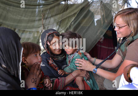 A local Afghani woman, from the Kuchi Tribe, located in the city of Gardez, Afghanistan, tries to comfort her daughter, as US Army (USA) Major (MAJ) Mary V. Krueger, 321st Civil Affair Battalion, gives the child an examination. MAJ Krueger is assigned to the Surgeon Cell, for the Combined Joint Civil Military Task Force (CJCMOTF), which operate an ambulatory clinic that provides vaccinations, acute and preventive medical care for members of the local Tribes. US specialist helping Afghan nomads Stock Photo