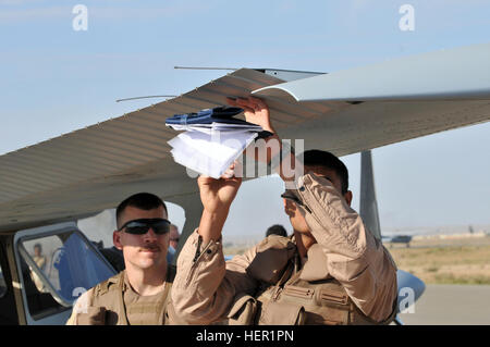 An Iraqi air force flight trainee is inspecting the underside of the wing of his Cessna 208 Caravan as part of his pre-flight inspection. U.S. Air Force Capt. Craig Morash, with the 52nd Expeditionary Flight Squadron, at Kirkuk, Iraq, is making sure  his Iraqi air force flight trainee is inspecting his plane correctly. The 52nd Expeditionary Flight Squadron, at Kirkuk, Iraq is teaching Iraqi air force trainees how to pre-flight and fly the Cessna 208 Caravan and the Cessna 172 Skyhawk, on Forward Operating Base Warrior, Nov. 10. Iraqi Air Force learns to fly 129387 Stock Photo