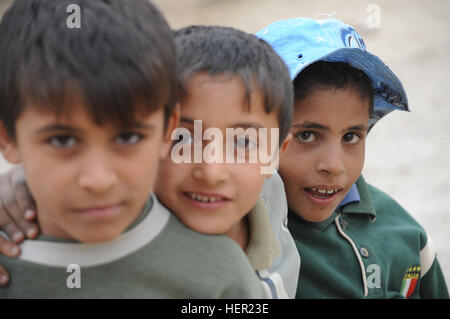 Iraqi boys pose with each other while U.S. Soldiers from Bravo Company, 2nd Battalion, 6th Infantry Regiment, 2nd Brigade Combat Team, 1st Armored Division, patrol the streets of Al Delami, south of Baghdad, on Nov. 20. Patrol in Al Delami 131065 Stock Photo