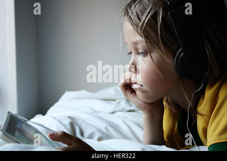 Boy wearing headphones using digital tablet Stock Photo