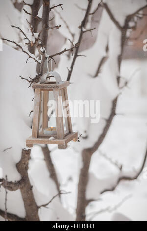 Wooden lantern hanging on a tree in the snow Stock Photo