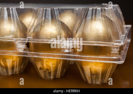 Golden eggs in a plastic box on golden background Stock Photo