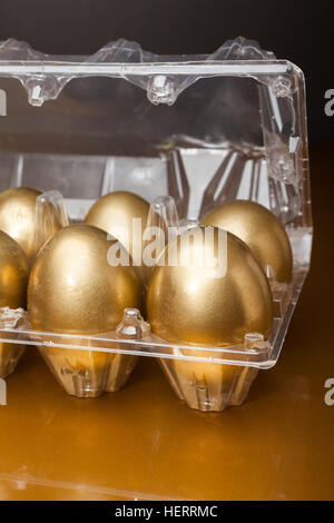 Golden eggs in a plastic box on golden background Stock Photo