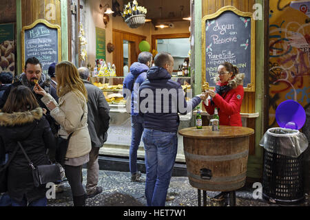 Naples, Italy - December 9, 2016: People in the street still eat cooked food at the moment, in front of a typical Neapolitan fry. Stock Photo
