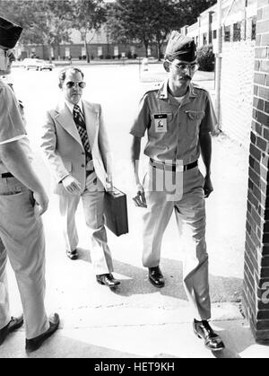 Convicted of the murder of 102 Vietnamese civilians  - the My Lai Massacre -  former U.S. Army Lieutenant William Calley (sunglasses) is escorted from the Fort Benning, Georgia confinement facility to a federal appeals court in nearby Columbus, Ga. At a later date, Calley's original sentence of life in prison was turned into an order of house arrest, but after three years, President Richard Nixon reduced his sentence with a presidential pardon. Stock Photo