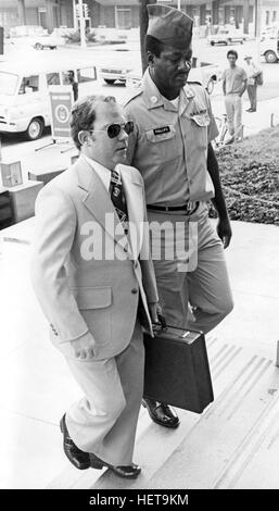 Convicted of the murder of 102 Vietnamese civilians  - the My Lai Massacre -  former U.S. Army Lieutenant William Calley (sunglasses) is escorted from the Fort Benning, Georgia confinement facility to a federal appeals court in nearby Columbus, Ga. At a later date, Calley's original sentence of life in prison was turned into an order of house arrest, but after three years, President Richard Nixon reduced his sentence with a presidential pardon. Stock Photo