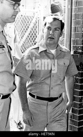 Convicted of the murder of 102 Vietnamese civilians  -the My Lai Massacre - former U.S. Army Lieutenant William Calley (center) is escorted from the Fort Benning, Georgia confinement facility to a federal appeals court in nearby Columbus, Ga. At a later date, Calley's original sentence of life in prison was turned into an order of house arrest, but after three years, President Richard Nixon reduced his sentence with a presidential pardon. Stock Photo