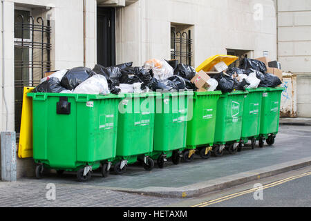 Overflowing commercial wheelie bin; rubbish bins on city centre street, Liverpool, UK Stock Photo