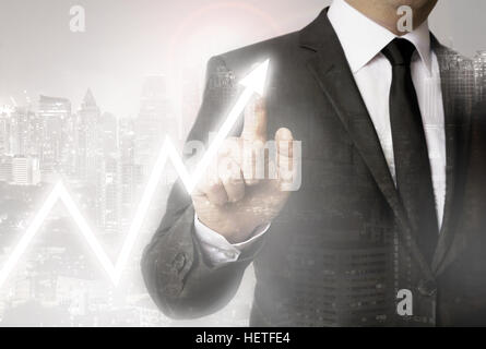 Businessman with city background showing stock market. Stock Photo