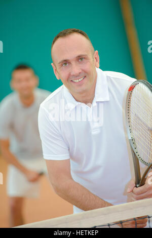 middle-aged man playing tennis Stock Photo