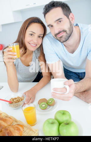 young happy couple having breakfast together with fruits and juice Stock Photo