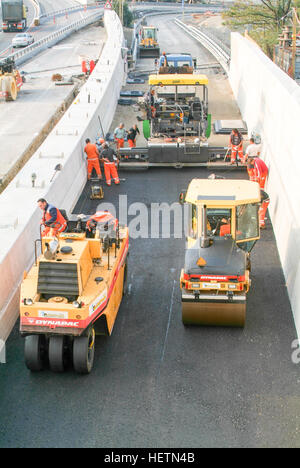 Bissone, Switzerland - 30 October 2009: Workers and vehicles during the asphalting of the highway at Bissone on Switzerland Stock Photo