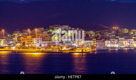 AGIOS NIKOLAOS, CRETE - AUGUST 2, 2012: Tourists relax in the outdoor restaurants along the waterfront of lake Voulismeni at night Stock Photo