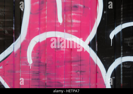 Detail of painted wall with so called 'graffiti', in pink, white and black. Stock Photo