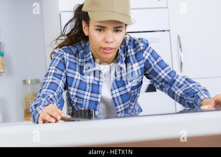 young repair man measuring kitchen cabinet Stock Photo