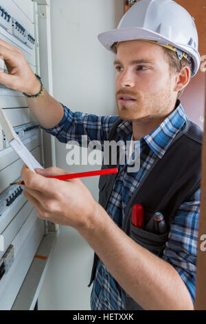 young electrician working on electric panel Stock Photo