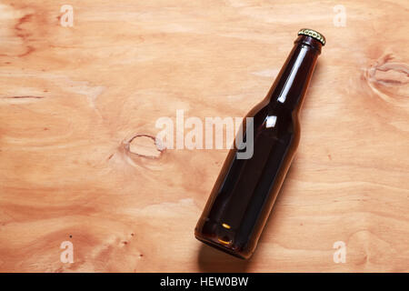 Beer bottle with no label on a textured wooden surface Stock Photo