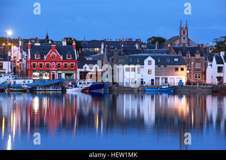 Stornoway, capital of the Isle Of Lewis, historic harbour, with boats, fishing vessels and cottages, at dusk Stock Photo