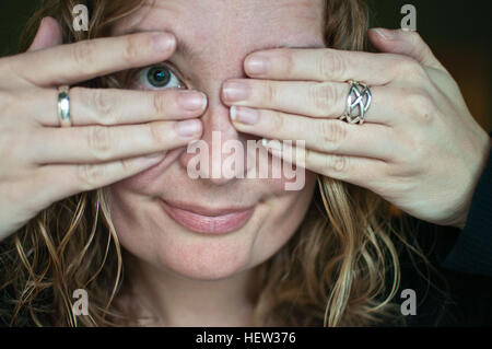 Close up portrait of woman covering eyes Stock Photo