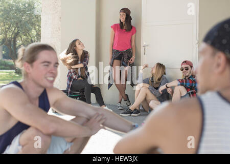 Friends talking and standing outside building Stock Photo