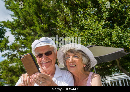 Happy senior couple using mobile phone Stock Photo