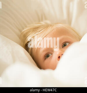 Portrait of blonde haired boy in bed Stock Photo