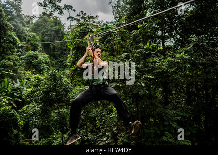 Man on zip wire in forest, Ban Nongluang, Champassak province, Paksong, Laos Stock Photo
