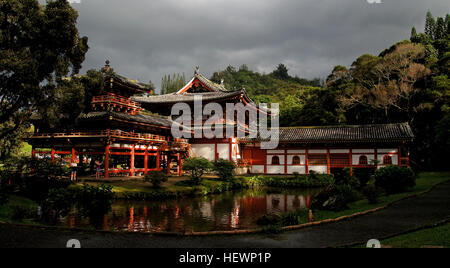 Located at the foot of the 2,000 foot Koʻolau Mountains in the Valley of the Temples in Oʻahu's Kaneohe Region sits the beautiful Byodo-In Temple.  While always a popular stop for visitors who seek locations off the beaten track, the Byodo-In Temple has become more popular since it was used as a filming location in the first season of the ABC Emmy Award winning drama series Lost, where it served as the home of the Korean woman Sun's powerful father.  The Byodo-In Temple was built in the 1960's to commemorate the 100th anniversary of the arrival of the first Japanese immigrant workers in Hawaii Stock Photo