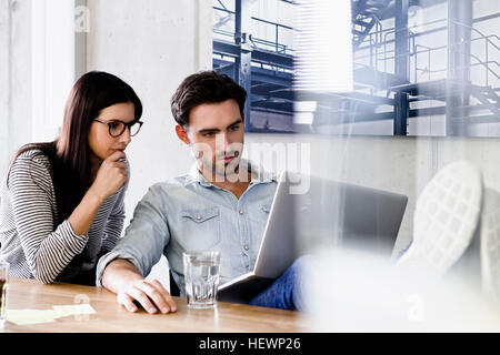 Colleagues in office using laptop Stock Photo