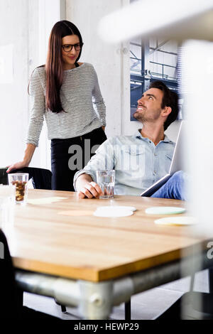 Colleagues in office using laptop Stock Photo