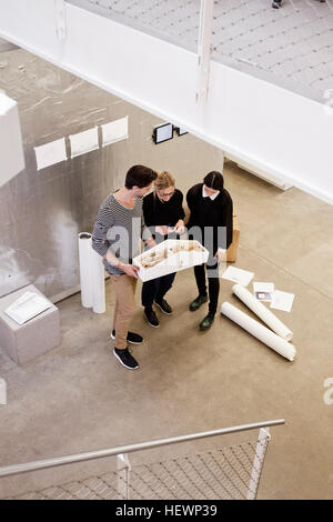 Architects in office looking at architectural model Stock Photo