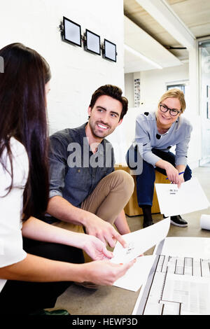 Architects in office discussing blueprints Stock Photo
