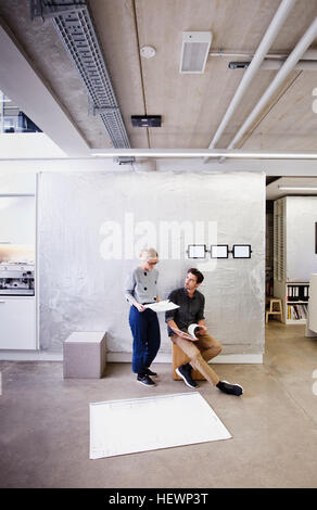 Architects in office discussing blueprints Stock Photo