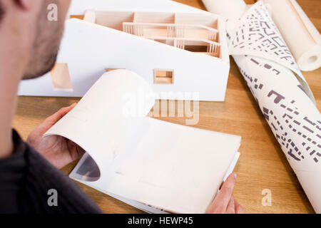 Over shoulder view of architect looking at book Stock Photo