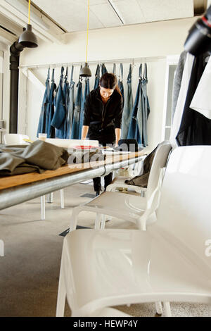 Fashion designer in sample room working at table Stock Photo