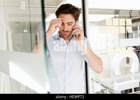 Businessman in office using mobile phone Stock Photo
