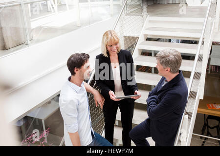 Business people with digital tablet talking on stairway Stock Photo