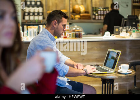 Man sitting in cafe reading laptop Stock Photo
