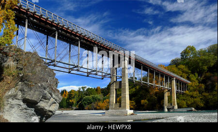 Situated 10 kilometres from Queenstown (off highway 6), the Old Lower Shotover Bridge was built in 1871 and offers foot traffic eye-catching 360 panoramic views of the Shotover River.  The original bridge was washed away in 1878 by flooding but rebuilt by the Public Works Department and re-opened in 1915. The bridge is172 metres long and stands16 metres from bridge to the river below. Stock Photo