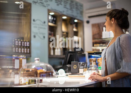 Young woman waiting at cafe counter Stock Photo