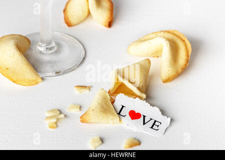 Cookies shaped like tortellini with the word love written on a paper and a glass of champagne.Horizontal image. Stock Photo