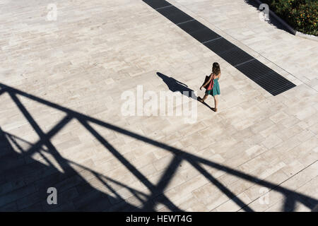 High angle view of woman wearing sundress walking through plaza, Rome, Lazio, Italy Stock Photo