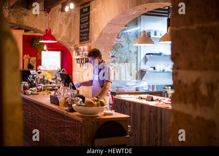 Restaurant owner working behind cash register Stock Photo