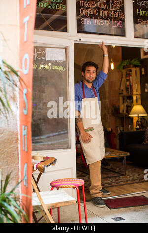 Restaurant owner standing at entrance of cafe, Palma de Mallorca, Spain Stock Photo